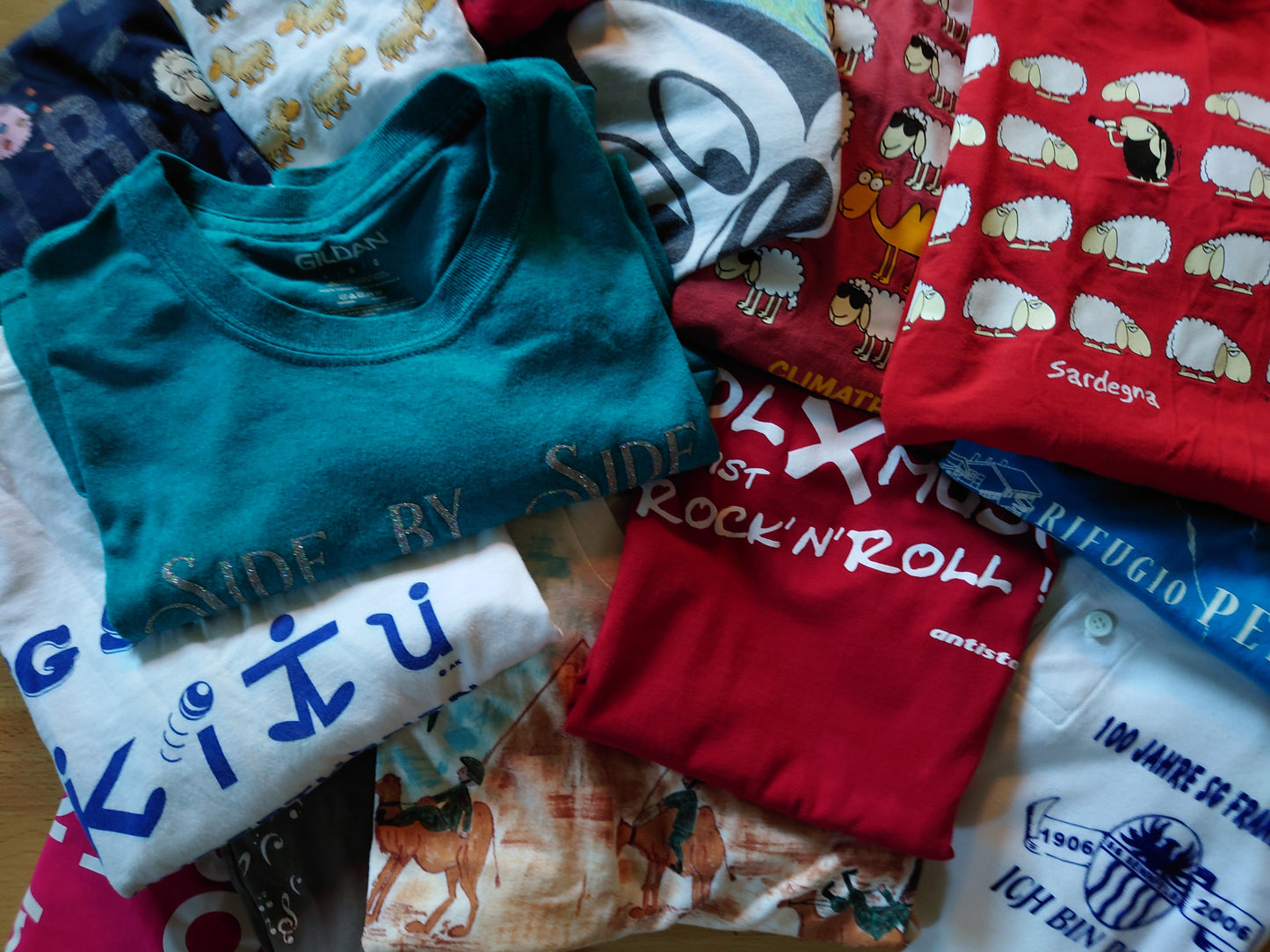 Ein Stapel T-Shirts in verschiedenen Farben und Designs.