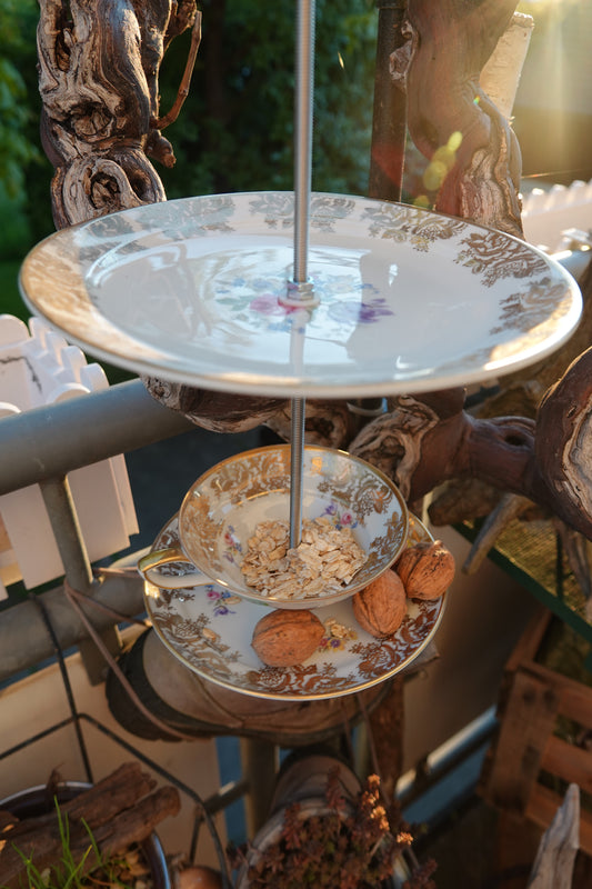 Handgemachte Vogelfutter-Etagere aus Vintage-Tasse und Porzellanteller, verbunden mit Edelstahlstange zum Aufhängen.
